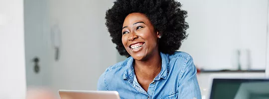 Profissional do RH sorri durante o expediente