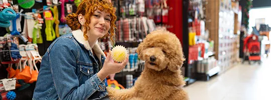 Mulher brinca com o seu cachorro dentro do pet shop