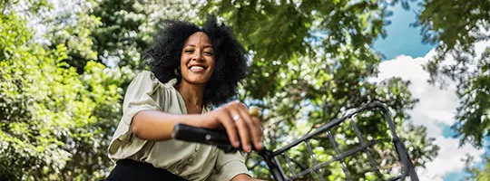 Mulher usa uma bicicleta para se deslocar até o local de trabalho