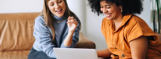 Profissionais colaborando em notebook durante atividade conjunta, representando engajamento no trabalho e adaptação às mudanças no ambiente profissional