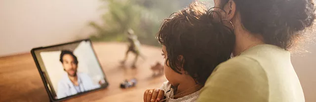 Na foto, mãe e filho fazem sessão de telemedicina de sua casa