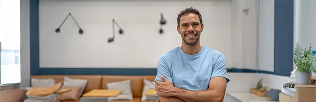 Jovem empresário sorri no seu estabelecimento