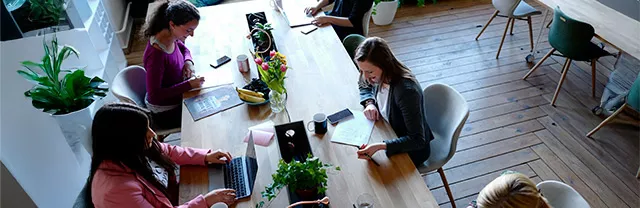 Foto mostra mulheres trabalhando juntas em um coworking