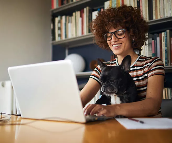 Mulher trabalha em casa. Ela paga a internet com a carteira Home Office do Pluxee Multibenefícios.