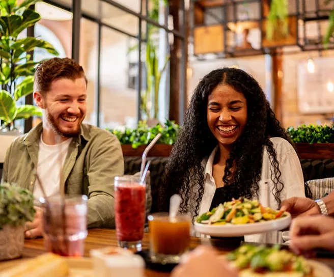 Colegas de trabalho almoçam em um restaurante usando o cartão vale-refeição