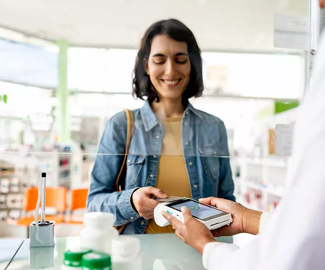 Mulher paga a conta da farmácia com o desconto que conseguiu com Pluxee
