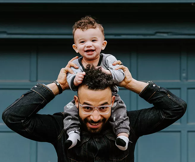 Pai brinca com seu filho na frente de casa