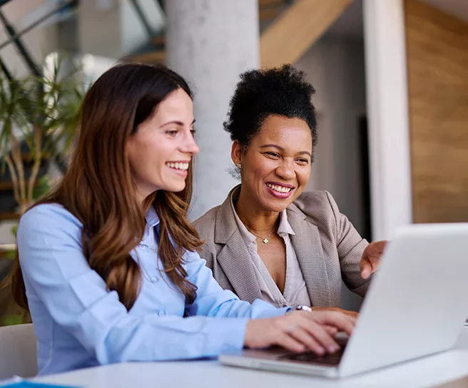 Foto mostra duas mulheres trabalhando juntas no escritório