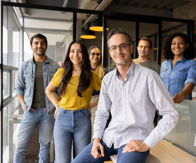 Foto mostra um grupo de pessoas  no trabalho