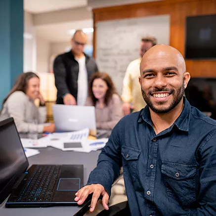 Jovem profissional sorri para a câmera durante uma reunião