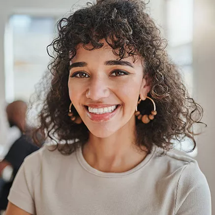 Jovem profissional sorri durante seu dia de trabalho