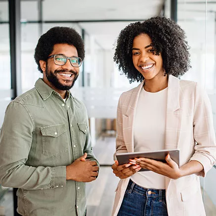 Dois funcionários sorriem para a câmera