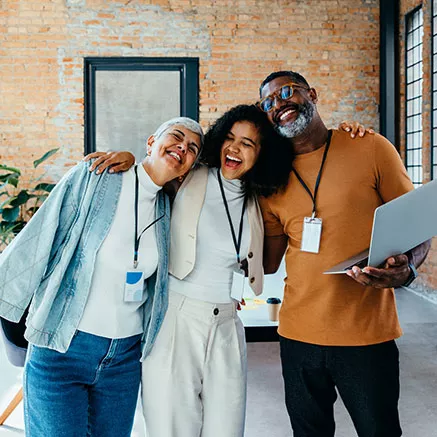 Três colegas de trabalho comemoram uma entrega de sucesso