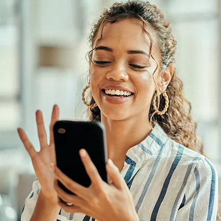 Foto mostra uma mulher usando o celular