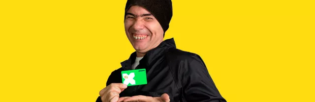 Personagem do humorista Marco Luque, Jackson Faive, segurando o cartão Pluxee