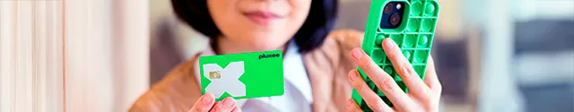 Mulher segura um cartão Pluxee Multibenefícios em uma mão